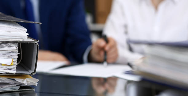 istock Binders with papers are waiting to be processed with bookkeeper. Internal Revenue Service inspector working place. View from above 1140722075