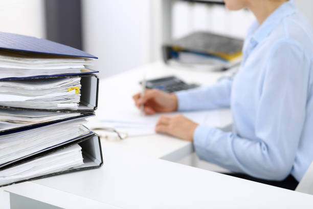 istock Unknown female bookkeeper or financial inspector calculating or checking balance, making report, close-up. Internal Revenue Service at work with financial document. Tax and audit concept 1140722104