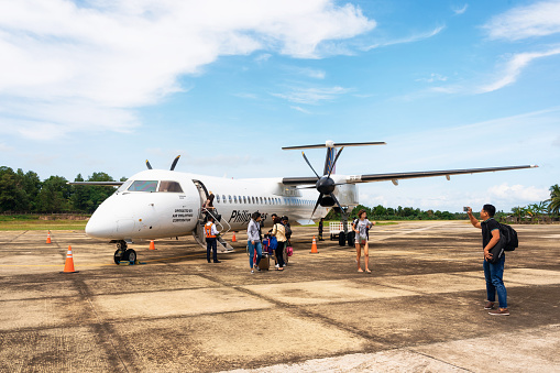 San Vicente, Philippines - January 30, 2019: Travellers leave Bombardier Q400 airplane Philippine Airlines at new small Airport in Palawan Island.