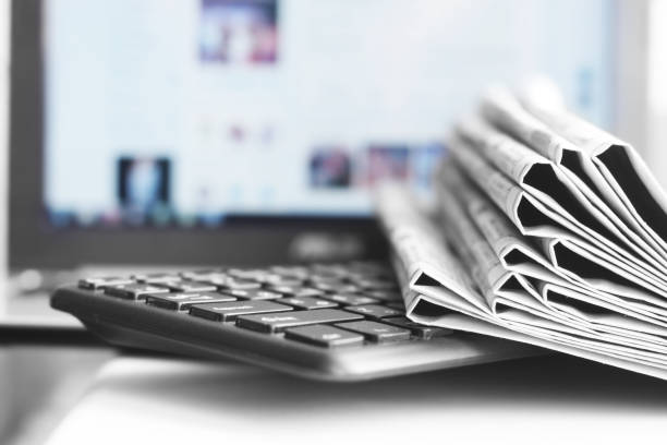 Newspapers and Laptop stock photo
