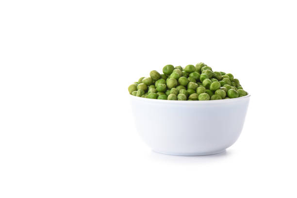 istock Green peas in a white bowl isolated on white background. 1140730578