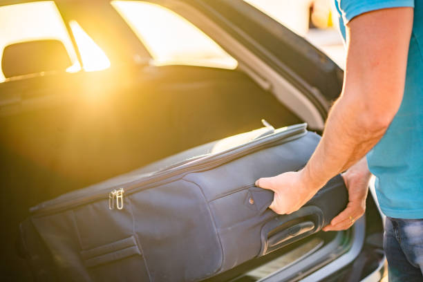 istock Close up males hands packing bag at car trunk 1140731117