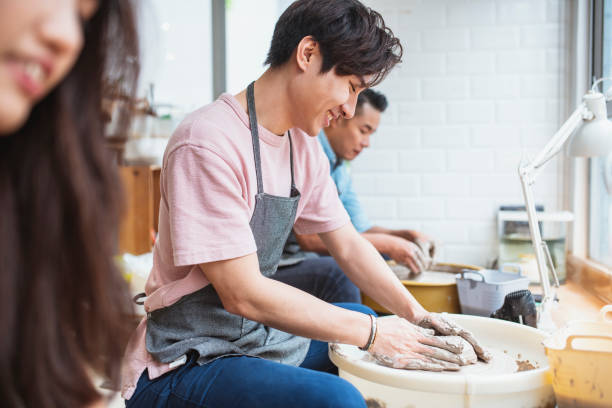 istock Young man shaping clay in a pottery class 1140731695