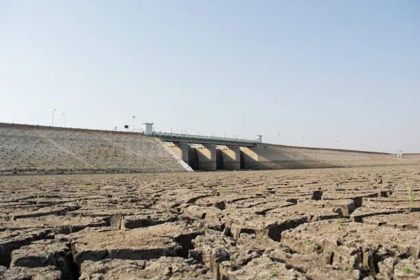 A dried up empty reservoir or dam during a summer heatwave, low rainfall and drought in north karnataka,India.