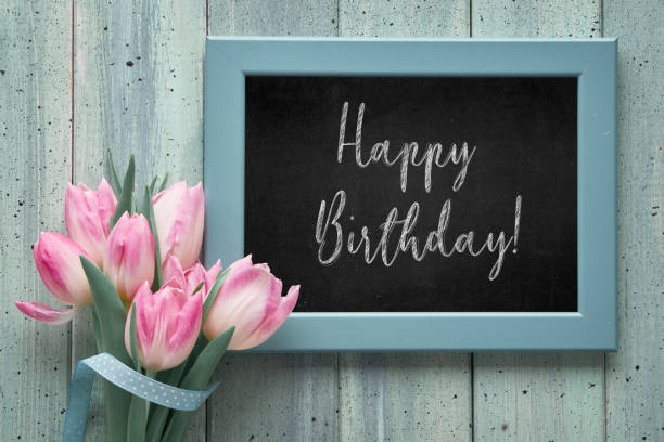 istock Springtime mint colored textured wooden background with pink tulips and blackboard with text 