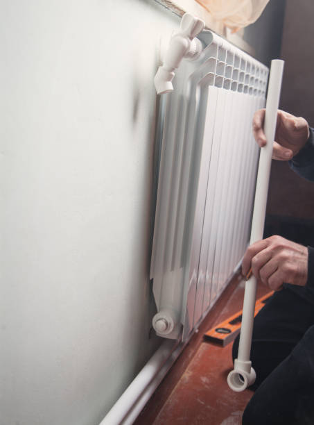 istock Installation and connection of new hot water radiator. 1140743247