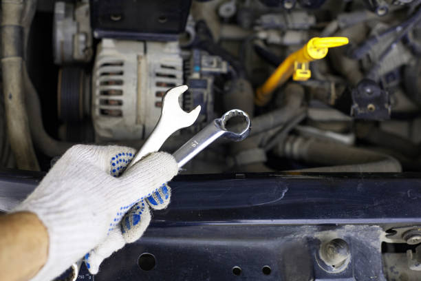 istock mechanic men with wrench repairing car engine at 1140745227