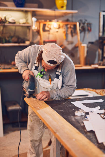 istock Male carpenter working on old wood in a retro vintage workshop. 1140746453