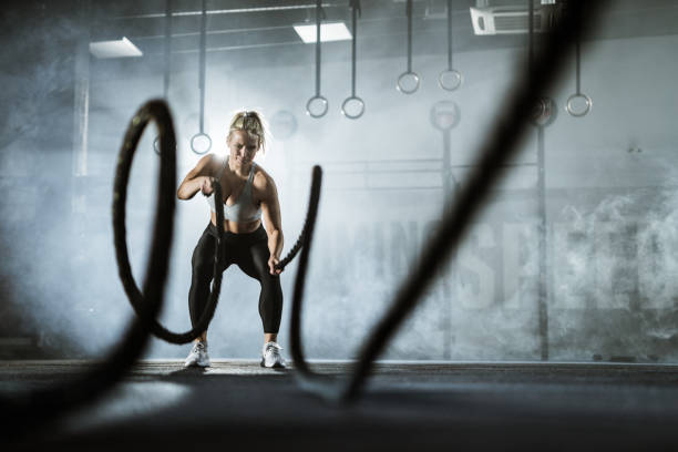 istock Female athlete exercising with battle ropes in a gym. 1140748890