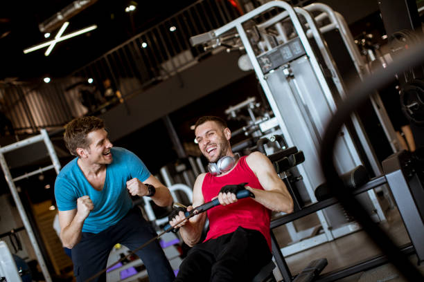 istock Young man with trainer doing exercise in the gym 1140749243