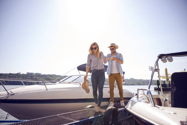 He will show  the surprise. Bearded handsome young man brought his girlfriend to the river to show her the surprise. boat on lake stock pictures, royalty-free photos & images