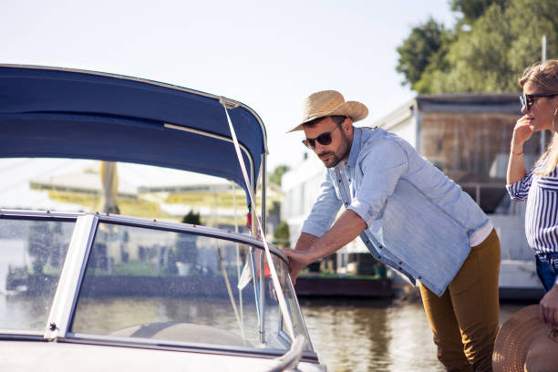 Handsome young man is checking out something on his speedboat.