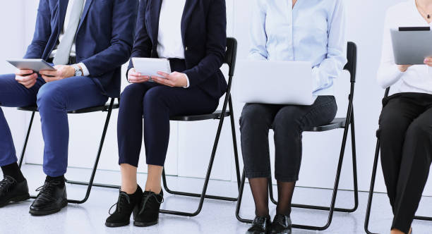 istock Group of business people sitting in office and waiting for job interview while using gadgets, close-up. Conference or training concepts 1140750555