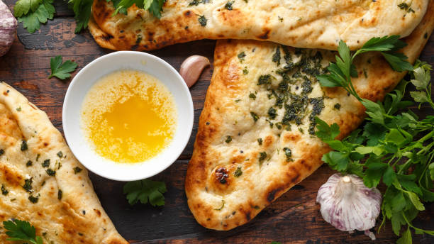 istock Indian naan bread with garlic butter on wooden table 1140752801