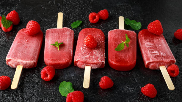 istock Homemade raspberry popsicles, ice lolly on rustic black background 1140753554