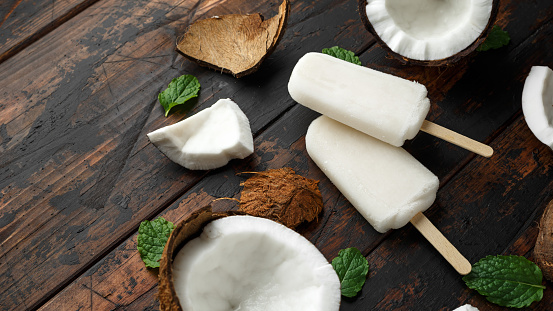 Homemade coconut popsicles, ice lolly, on wooden table. Summer food