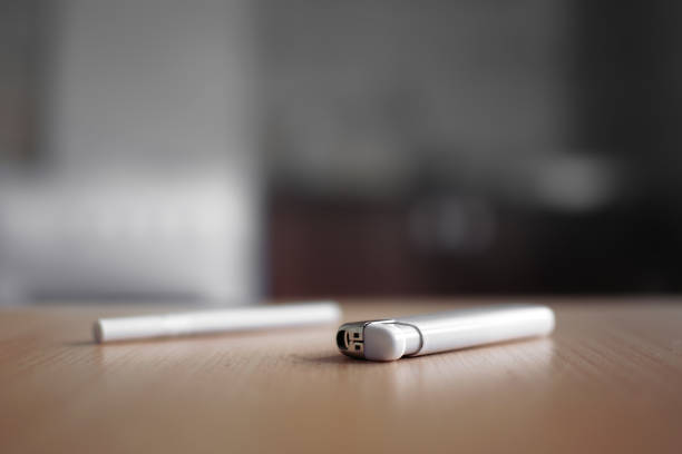 Closeup mans hand holding a burning metal gasoline lighter. Isolated on black.