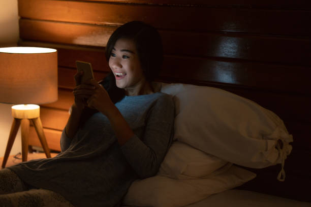 istock asian woman with smart phone while laying on bed 1140756154