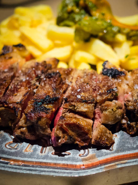 nahaufnahme eines mit gebratenen kartoffeln gegrillten rippens, spanisches essen - skirt steak steak close up grilled stock-fotos und bilder