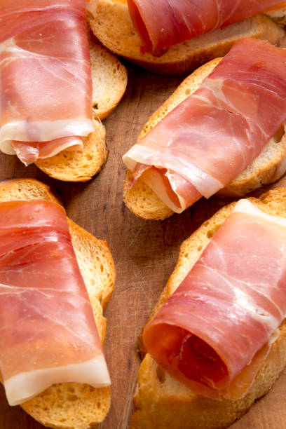 istock Crostini with serrano ham on wooden board, low angle view. Close-up. 1140757419