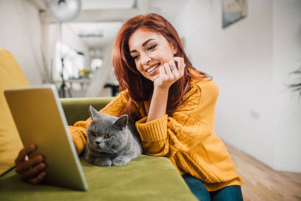 istock Girl using digital tablet and hugging a cat 1140760005