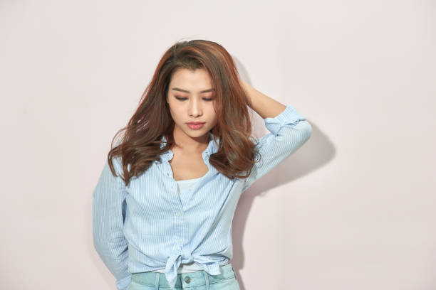 istock Beautiful lady in trendy blue blouse looking at camera with confident face expression while standing on light pink background 1140760398