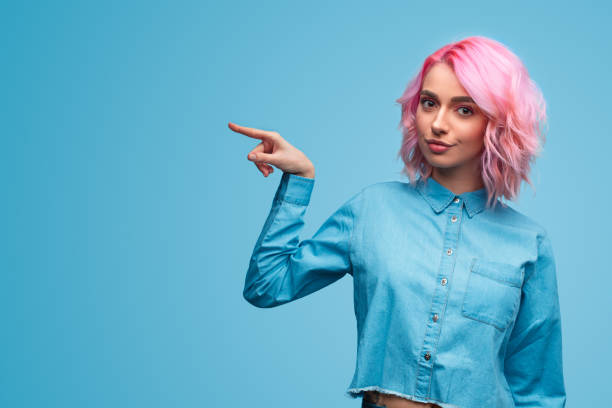 istock Bright stylish woman pointing away 1140764334
