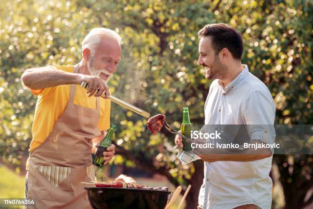 Familie Die Im Garten Grillfest Hält Stockfoto und mehr Bilder von Vater - Vater, Grill-Zubereitung, Grillfest