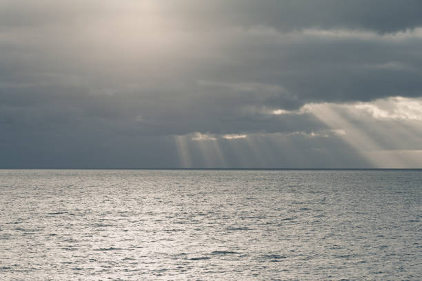 istock cloudy sky with sun rays in the open sea 1140773487