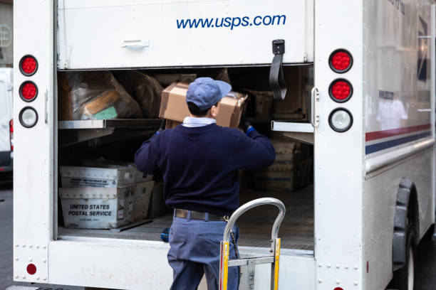 USPS Postal worker load truck New York City, USA - February 4, 2019: USPS Postal worker load truck parked on street of midtown of New York City united states postal service photos stock pictures, royalty-free photos & images