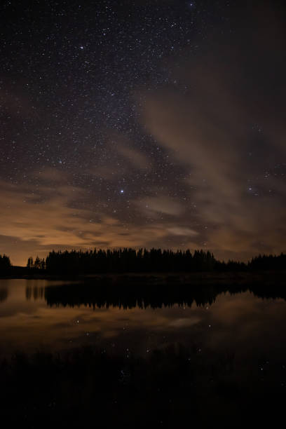 istock Night sky with starts in a  Conemara lake with Pine Forest around 1140775956