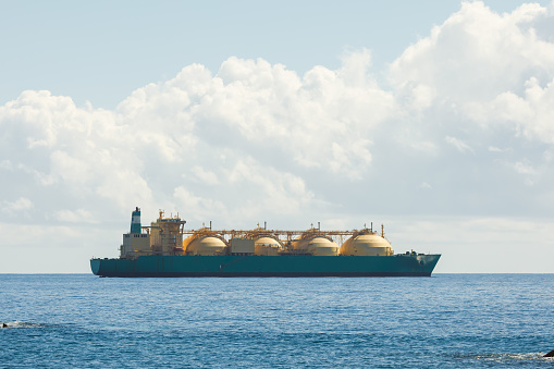 liquefied natural gas LNG transportation tanker ship, blue sea and sunny sky background with copy-space