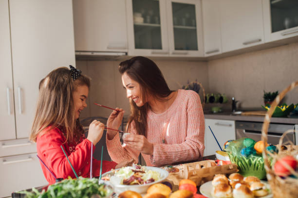 istock Happy woman coloring Easter eggs with young girl 1140776441