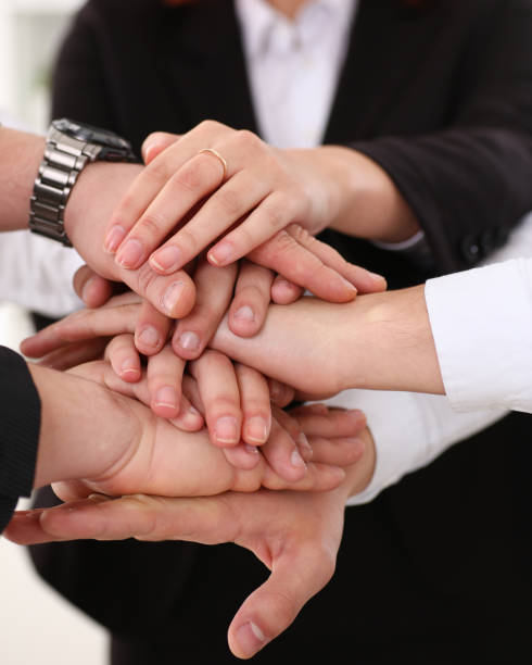 istock Group of people in suits crossed hands pile 1140778182
