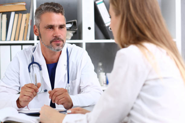 istock Smiling handsome mature doctor communicate with patient 1140779379