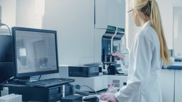 istock Female Research Scientist Working with Medical Analyzing Machine for Testing Tubes with Blood Sample. Scientist Works in Innovative Pharmaceutical Genetic Research Laboratory. 1140779515