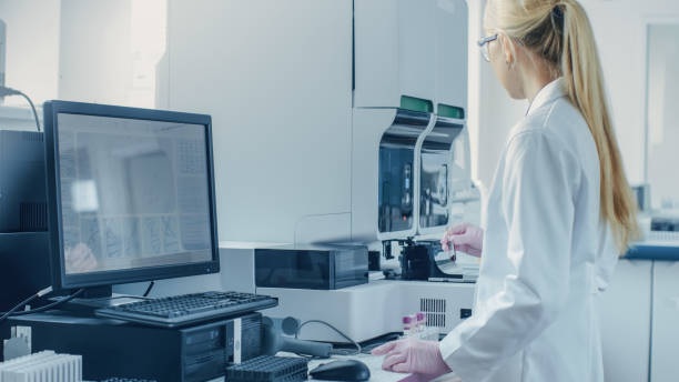 istock Female Research Scientist Working with Medical Analyzing Machine for Testing Tubes with Blood Sample. Scientist Works in Innovative Pharmaceutical Genetic Research Laboratory. 1140779554