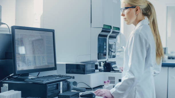 istock Female Research Scientist Working with Medical Analyzing Machine for Testing Tubes with Blood Sample. Scientist Works in Innovative Pharmaceutical Genetic Research Laboratory. 1140779592