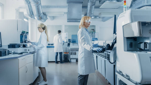 istock Team of Research Scientists Working On Computer, with Medical Equipment, Analyzing Blood and Genetic Material Samples with Special Machines in the Modern Laboratory. 1140779604