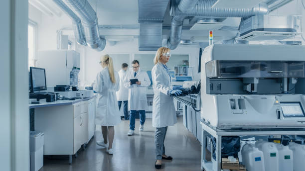 의료 장비를 사용 하 여 컴퓨터에서 작업 하는 연구 과학자 팀은 현대 실험실에서 특수 기계로 혈액 및 유전 물질 샘플을 분석 합니다. - scientist research group of people analyzing 뉴스 사진 이미지