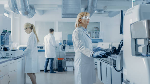 istock Team of Research Scientists Working On Computer, with Medical Equipment, Analyzing Blood and Genetic Material Samples with Special Machines in the Modern Laboratory. 1140779754