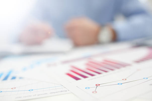 Businessman at workplace office problem with infographics closeup. White collar check money papers stock exchange market earnings list partnership agreement discussion concept