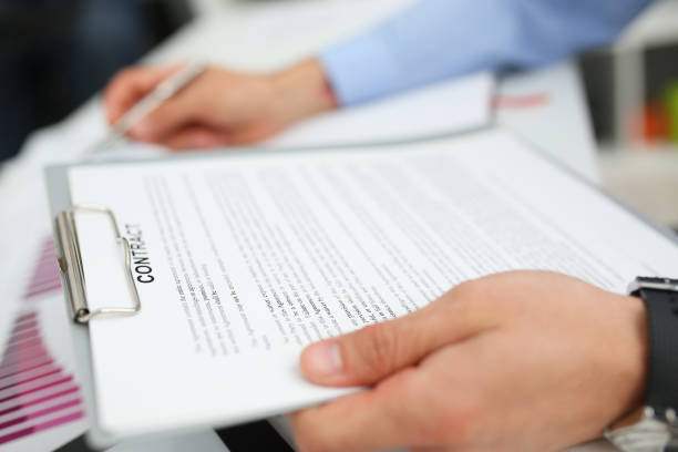 istock Male arm in suit offer contract form on clipboard pad 1140781489