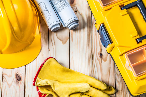 istock gloves blueprints toolbox and helmet on wood 1140784426