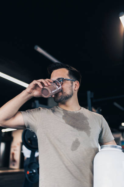 istock Young man drinks protein shake in fitness gym 1140787321
