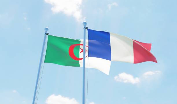 France and Algeria, two flags waving against blue sky