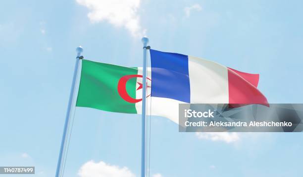 France And Algeria Two Flags Waving Against Blue Sky Stock Photo - Download Image Now