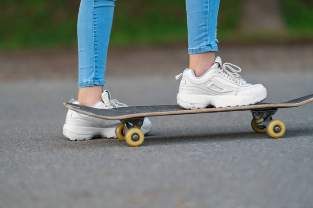 Legs of man riding on the skateboard.