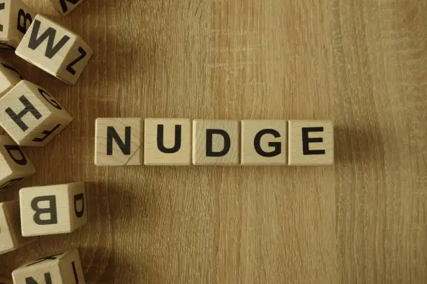 Nudge word from wooden blocks on desk