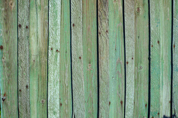 stara zardzewiała drewniana ściana z rzędu desek, pomalowana na zielono z plamami pierwszej warstwy drewna. - wood shutter rusty rust zdjęcia i obrazy z banku zdjęć